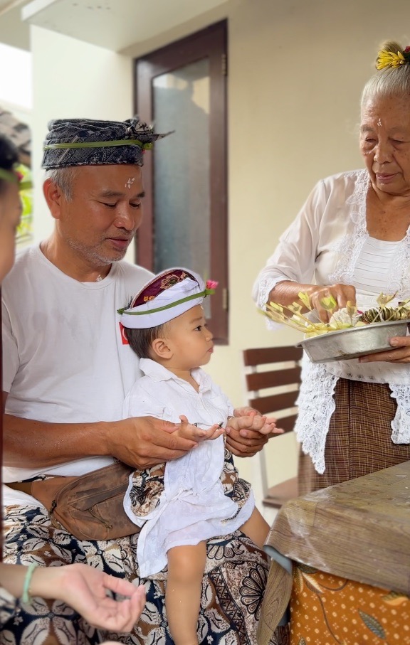 Balinese ceremonial offerings with flowers and incense smoke